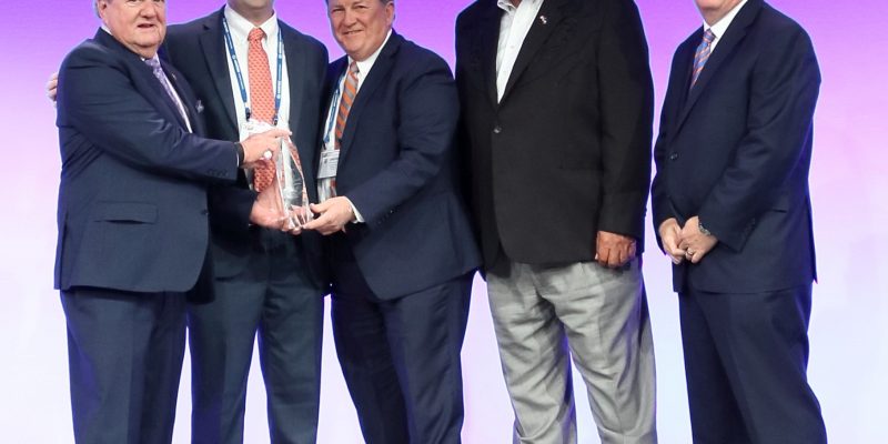 Team standing with AGC award trophy