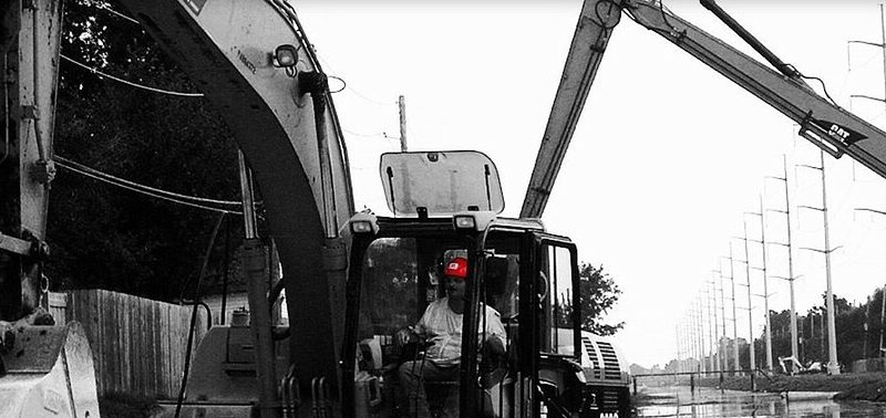 Cycle worker operating large bucket scoop
